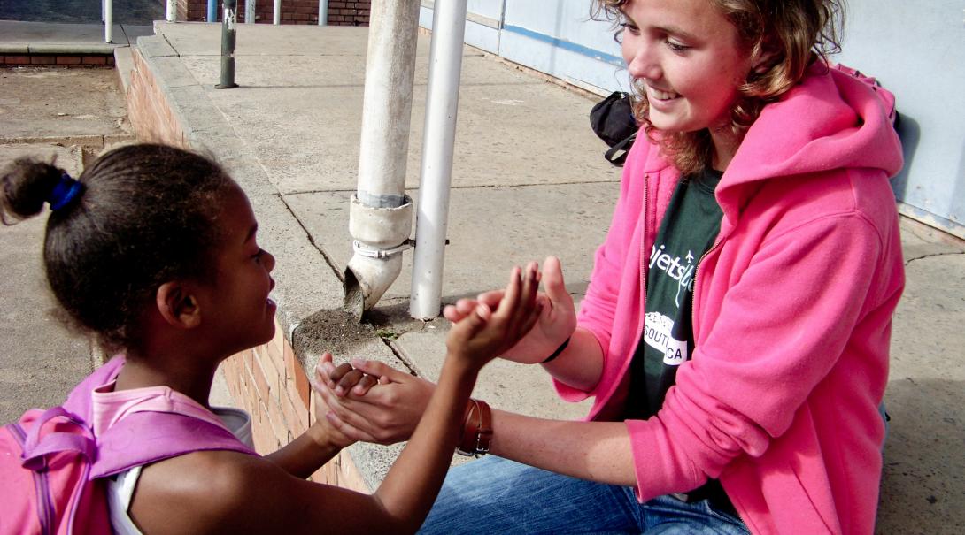 A Projects Abroad volunteer with children in South Africa plays a game during break time Childcare volunteer plays a game with a child during her volunteer work with children in South Africa
